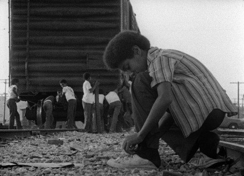 Kids playing by the train in the film KILLER OF SHEEP; a Milestone Film & Video release.